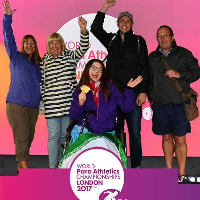 Jenni with a group of others holding up a gold medal.