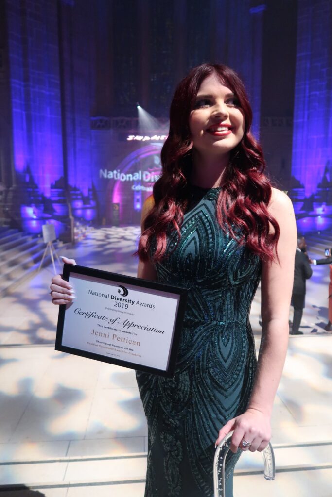 Jenni holding a framed certificate which reads national diversity awards 2019 certificate of appreciation Jenni Pettican shortlisted nominee for the positive role model award for disability