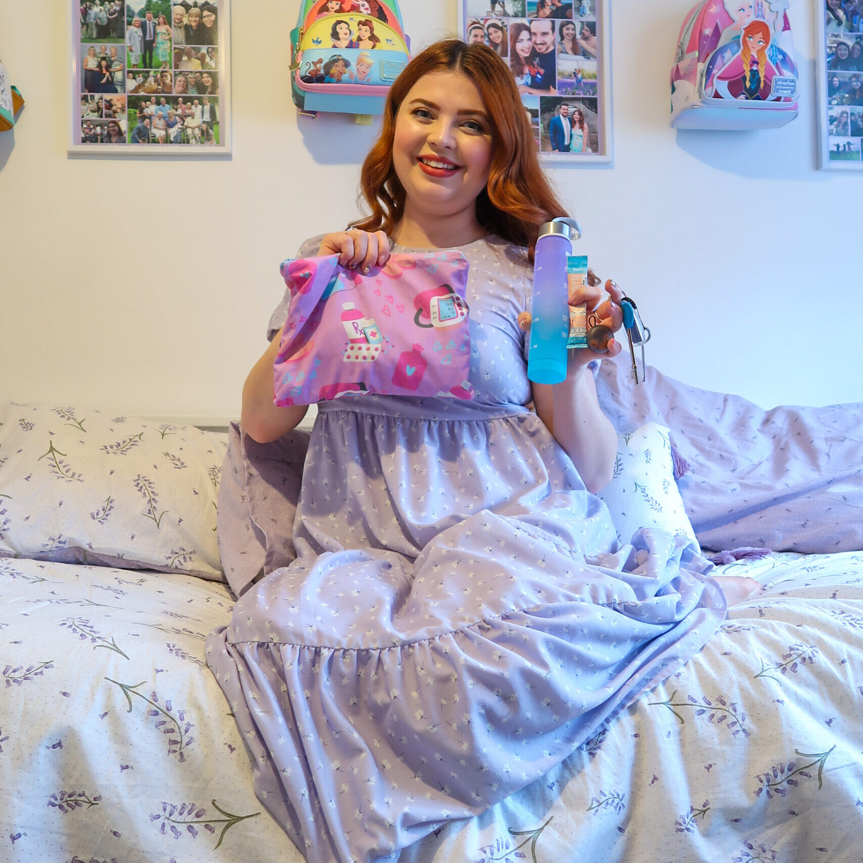 Jenni is sat on her bed holding her flare up bag in one hand and some items from inside it in the other including a small water bottle, a sachet of electrolytes, her loop earplugs and a radar key