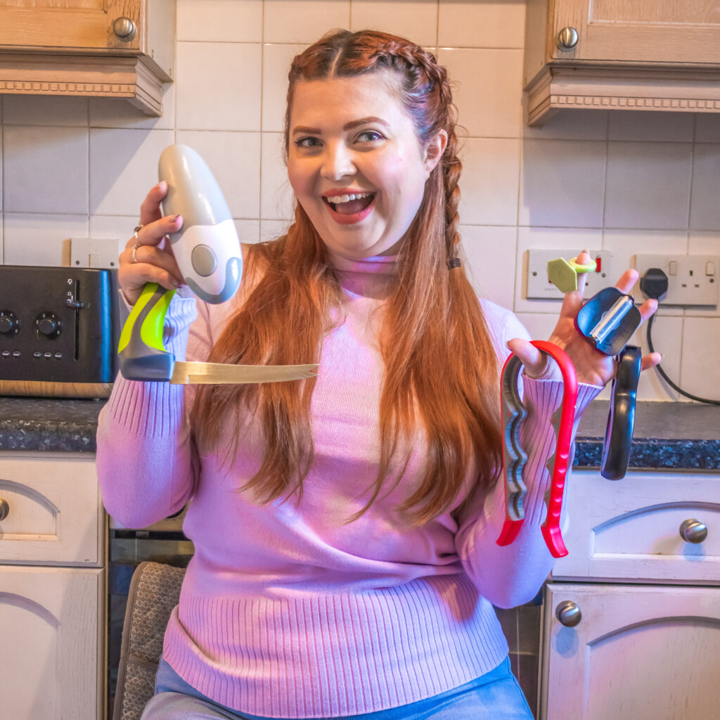 Jenni sat in the kitchen with various kitchen hacks and gadgets