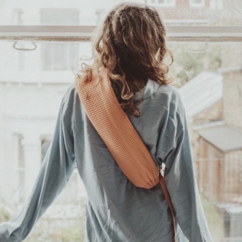 A woman with her back to the camera, wearing pajamas. She is modelling a YuYu bottle